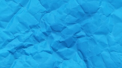 Abstract crumpled blue paper background with wavy surface texture. Crumpled blue vintage paper surface texture for background. Wrinkled paper background with copy space for text.