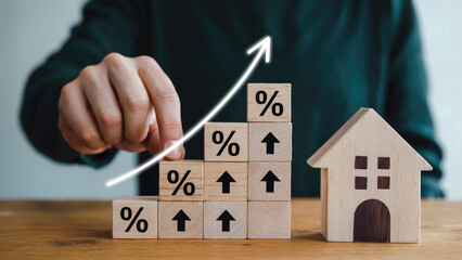 Rising interest rates symbolized by stacked blocks with percentage signs and upward arrows next to a house