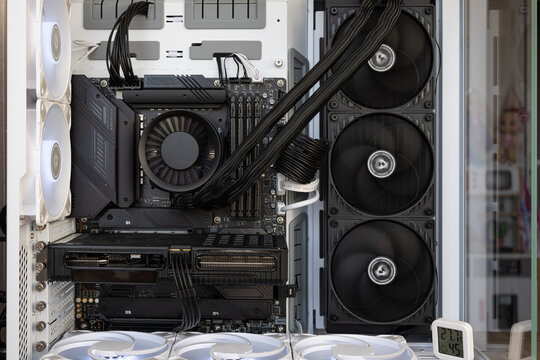 High-end PC build with liquid cooling, motherboard and GPU installed in white case.