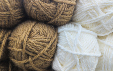  Brown and white yarn balls close-up in soft natural light