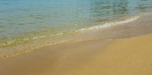 Crystal clear water gently washing golden sand on tropical beach