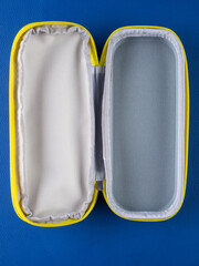 Close-up of a gray school pencil case in a hard format on a blue background