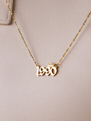 Close-up of a metallic gold pendant in the shape of 