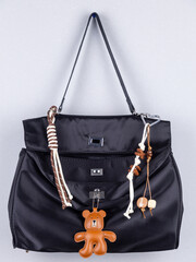Close-up of a stylish leather bag accessory featuring a detailed leather bear charm no black  bag