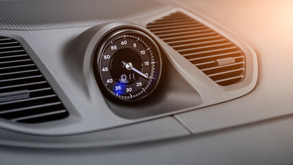 Close up of clock in retro style - details and controls of a modern car.