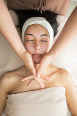 aesthetician preparing towel wrap on woman's face in spa setting medium shot
