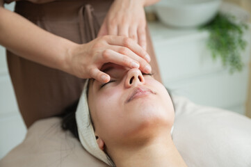 facial massage on young woman during spa session skincare treatment concept