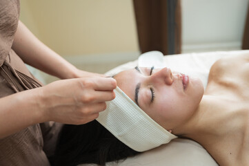 esthetician adjusting headband before beauty session skincare treatment concept