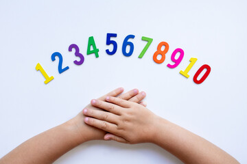 Fototapeta premium Child hands with colorful numbers on white background