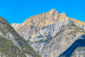 Mountain peak with forest rocks and blue sky Tyrol Austria.