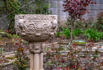Antique stone vase with patterns in the park.