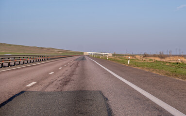 A deserted highway with patches on the asphalt.