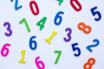 Colorful wooden numbers scattered on white background