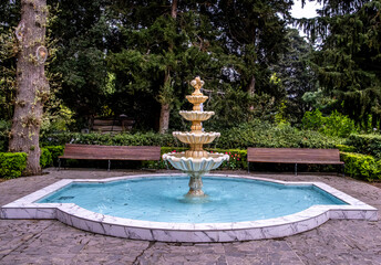 A small fountain in the park on a summer day.