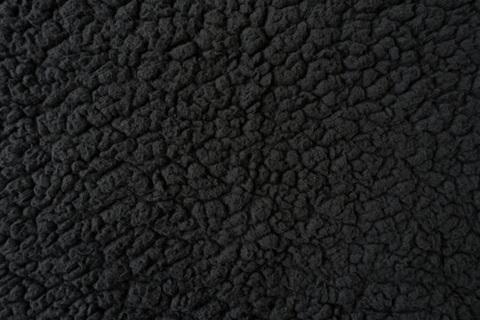 Natural black sherpa fleece texture. Soft sheep wool plain background. 