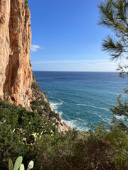 Bright coastal view with steep cliffs and turquoise sea under a clear blue sky. Vibrant and fresh atmosphere.