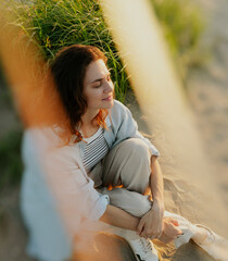 Portrait of relaxed young cute woman with closed eyes enjoying sunset and spending time in nature