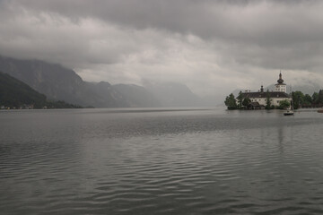 Fototapeta premium Dunkle Regenwolken über dem Traunsee, Blick auf Schloss Ort