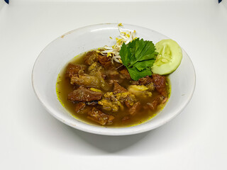 A warm bowl of traditional Indonesian beef stew soup with fresh vegetable garnish