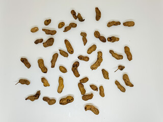 Dried medicinal herb roots scattered on a white background for traditional remedy concepts