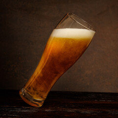 Beer. Jet of beer is poured into a beer glass, causing a lot of bubbles and foam