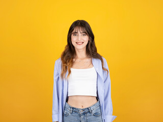 Beautiful young woman, portrait of satisfied cool caucasian brunette 20s beautiful young woman wearing white top shirt casual clothes looking camera smiling isolated on yellow background. Copy space.