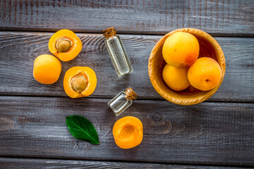 Fruit aroma oil. Apricot kernel oil on dark wooden background top view