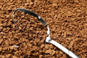 Spoon with aromatic instant coffee as background, closeup