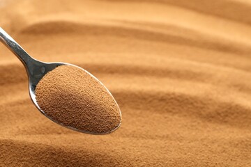 Spoon with aromatic instant coffee as background, closeup