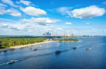 Cityscape viewed from high vantage point, modern architecture, dense array of tall buildings, greenery patches, urban landscape, calm water, serene atmosphere, boats, liveliness, blue sky, fluffy