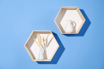 Honeycomb shaped shelves with decor on blue background
