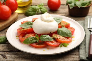 Tasty salad Caprese served with pesto sauce on wooden table, closeup