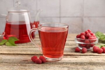 Tasty raspberry tea and berries on wooden table, closeup