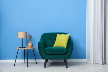Comfortable armchair and decor near blue wall indoors