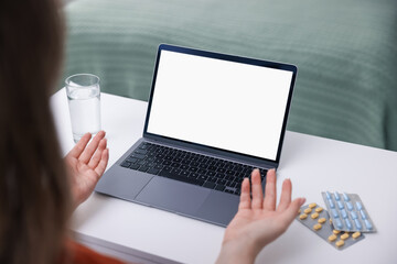 Woman having online consultation with doctor via laptop at table indoors, closeup