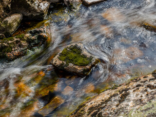 Flowing stream over mossy rocks with long exposure