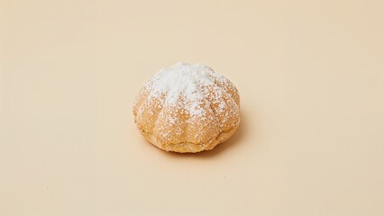 Showcasing pumpkin-shaped pastry sitting on smooth beige surface, with powdered sugar