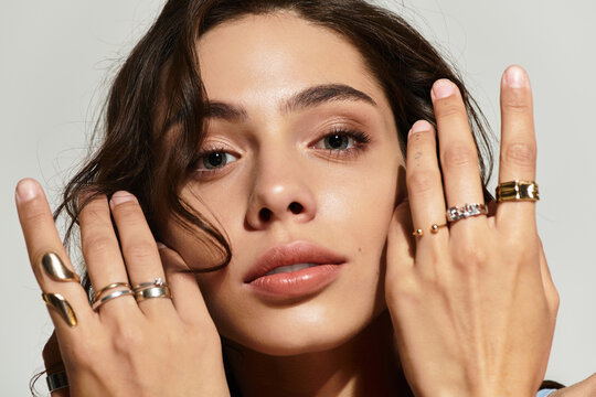 Captivating beauty in a studio with charming makeup and exquisite rings