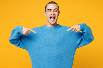 Young shocked surprised excited middle eastern man wearing blue sweatshirt casual clothes point...
