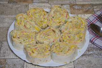 sliced pieces of pita bread with filling, sliced lavash rolls on a plate on the table