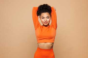 Young strong fitness trainer sporty woman sportswoman wear orange clothes spend time in home gym...