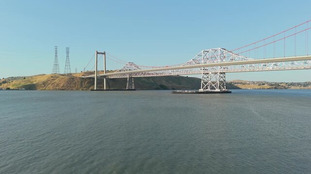 Panning drone perspective highlights the scale and symmetry of the Alfred Zampa Bridge spanning the northern California waterway.
