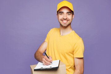 Young delivery guy employee man wears yellow cap t-shirt uniform workwear work as dealer courier...
