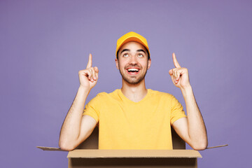 Young delivery guy employee man he wear yellow cap t-shirt uniform workwear work as dealer courier...