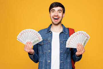 Young surprised boy student he wears denim casual clothes backpack bag hold in hand fan of cash...