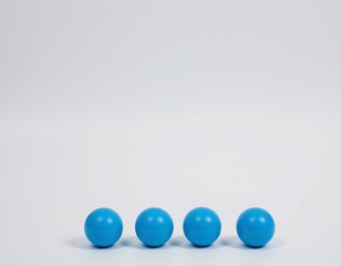 isolated four toy blue balls against a plain white background