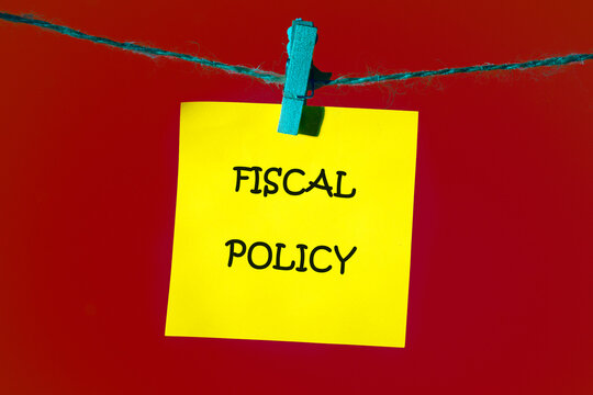 FISCAL POLICY words on a piece of yellow sticker in front of a red background