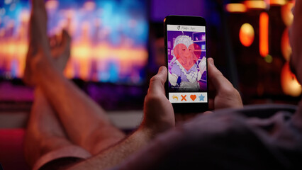 Person like an anime girl on waifu dating app smartphone over shoulder view sitting behind the computer