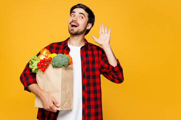 Young man wear casual clothes hold craft paper bag takeaway mock up with food products try hear you...