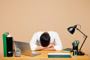 Young tired exhausted sad sick sleepy employee business man wear white shirt tie sit work put head...